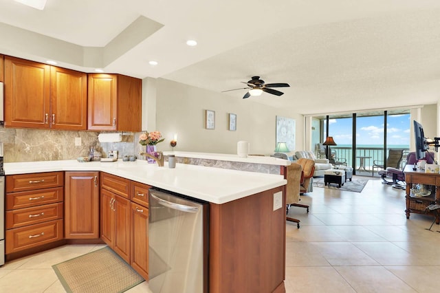 kitchen featuring ceiling fan, a wall of windows, kitchen peninsula, and dishwasher