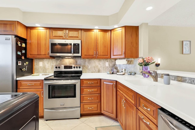 kitchen with tasteful backsplash, sink, appliances with stainless steel finishes, and light tile patterned flooring