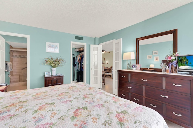 bedroom featuring a textured ceiling, a closet, a walk in closet, and connected bathroom