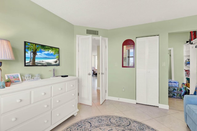 bedroom featuring light tile patterned floors, a closet, and a textured ceiling