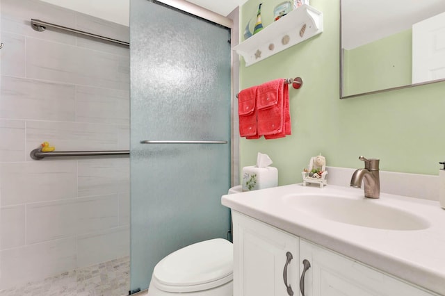 bathroom featuring toilet, an enclosed shower, and vanity