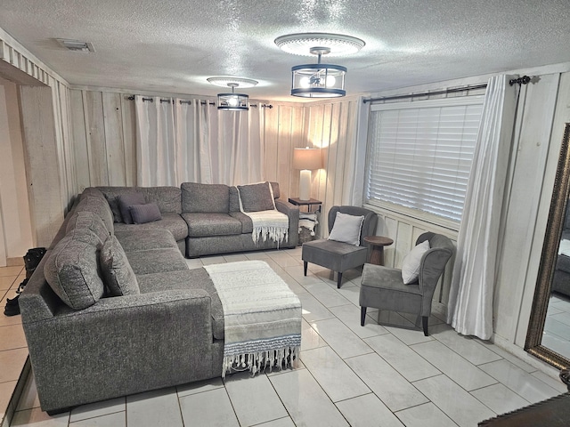 living room featuring a textured ceiling and light tile patterned floors