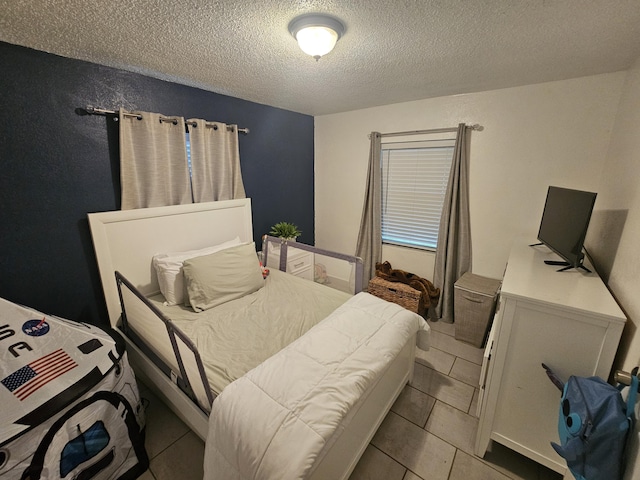 bedroom featuring a textured ceiling and light tile patterned floors