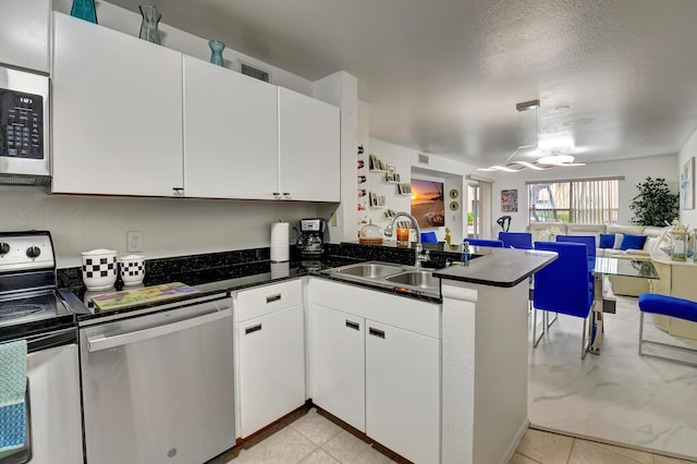 kitchen featuring white cabinets, appliances with stainless steel finishes, and kitchen peninsula