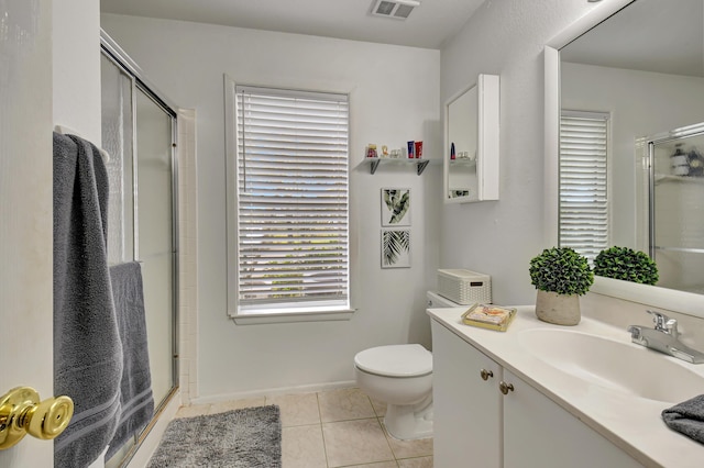 bathroom featuring a shower with shower door, a healthy amount of sunlight, and tile patterned floors