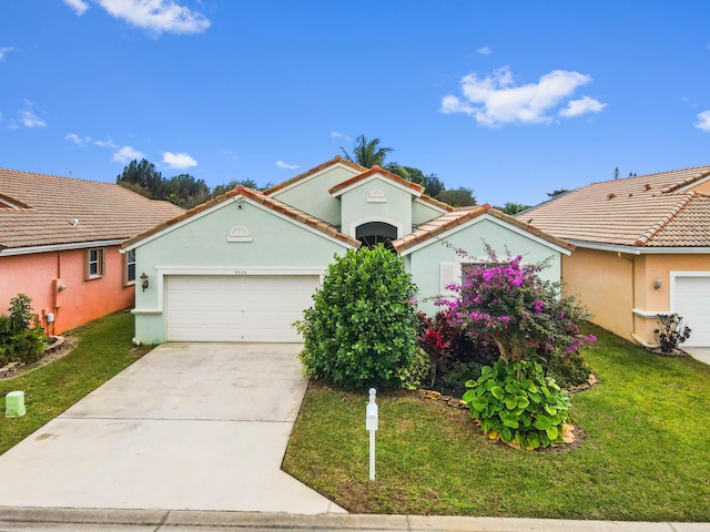 mediterranean / spanish-style house with a garage and a front lawn