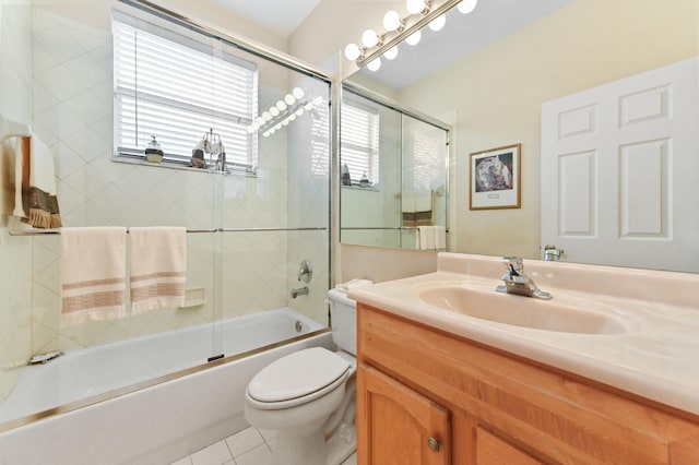 full bathroom with vanity, bath / shower combo with glass door, tile patterned floors, and toilet