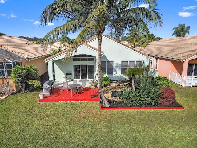 rear view of house with a yard and a deck