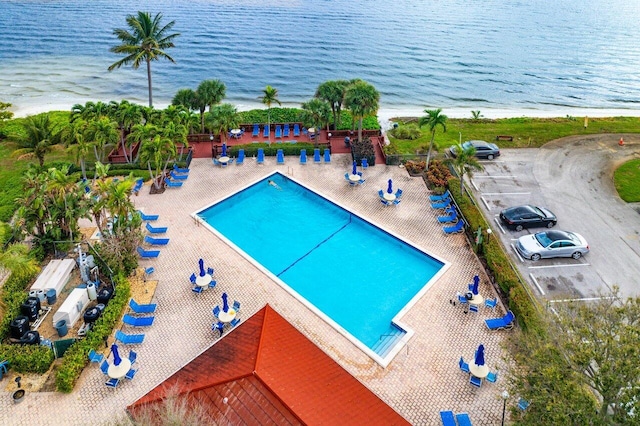 view of swimming pool featuring a patio area and a water view