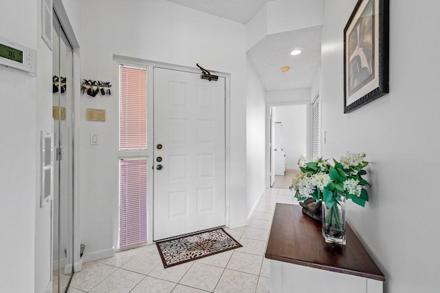 entrance foyer with light tile patterned flooring and a textured ceiling