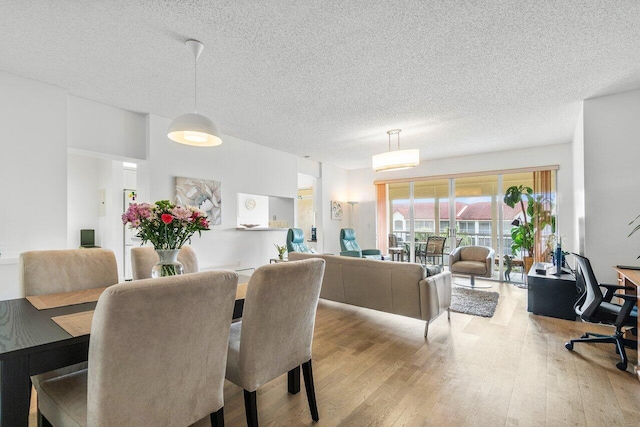 dining area featuring light hardwood / wood-style floors and a textured ceiling