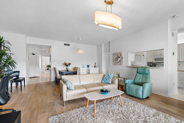 living room with light hardwood / wood-style flooring and a textured ceiling