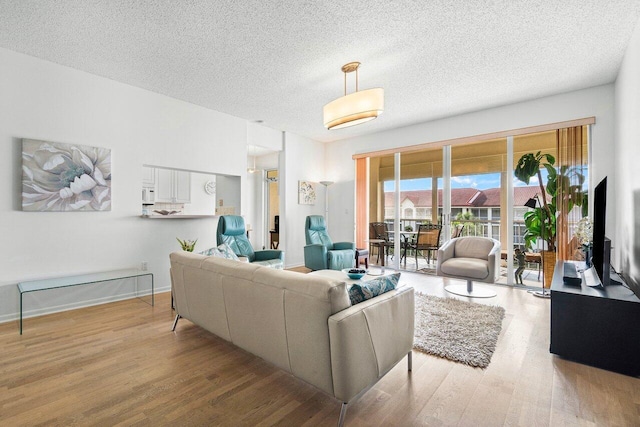 living room with a textured ceiling and light hardwood / wood-style floors