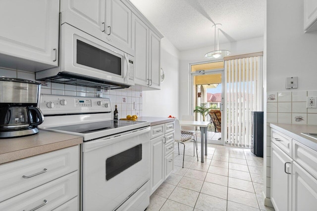 kitchen featuring white cabinetry, light tile patterned floors, a textured ceiling, and white appliances