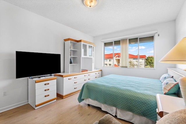 bedroom featuring light hardwood / wood-style floors and a textured ceiling