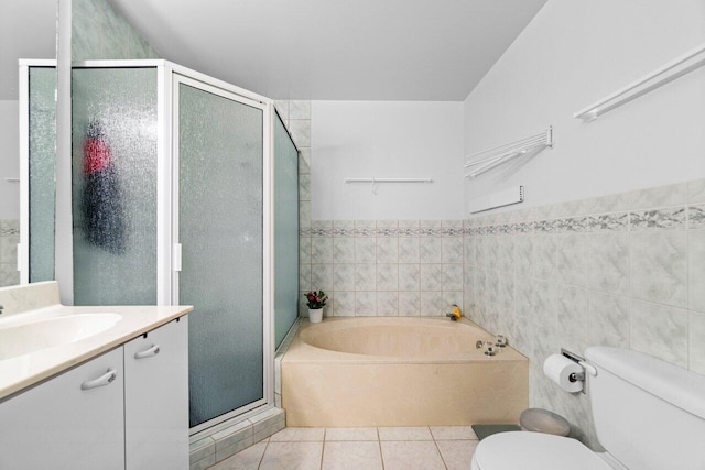 full bathroom featuring toilet, shower with separate bathtub, tile walls, vanity, and tile patterned flooring