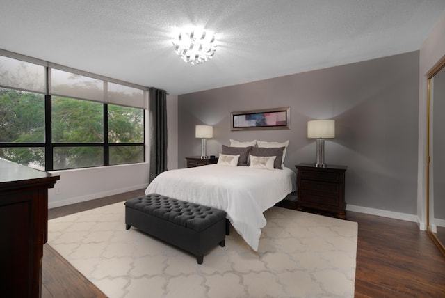 bedroom with dark hardwood / wood-style flooring and a textured ceiling