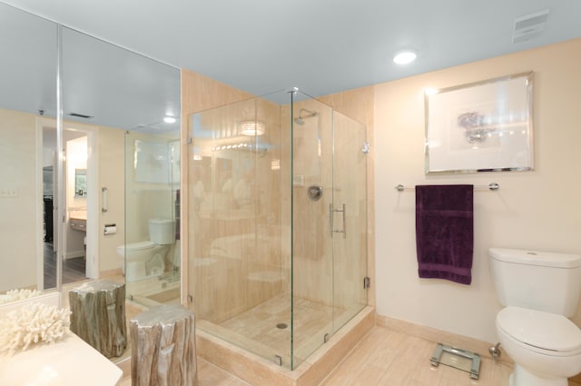 bathroom featuring vanity, an enclosed shower, and toilet