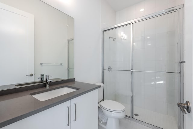 bathroom with vanity, a shower with shower door, and toilet