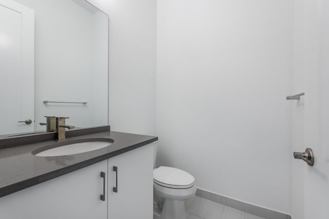 bathroom featuring toilet, tile patterned flooring, and vanity