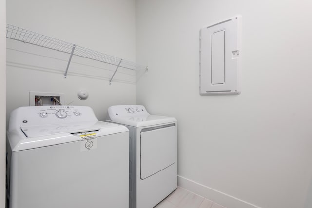 washroom with separate washer and dryer, light tile patterned floors, and electric panel