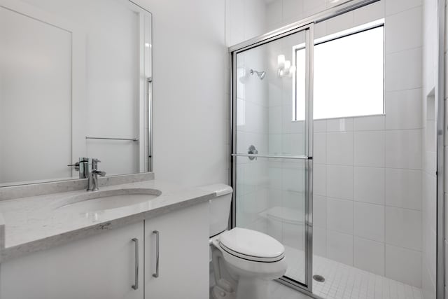 bathroom featuring toilet, walk in shower, and vanity