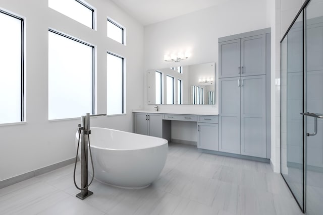 bathroom with vanity, a healthy amount of sunlight, and separate shower and tub