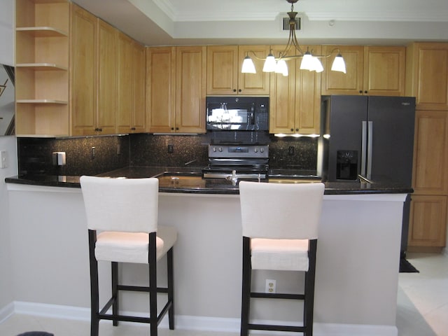 kitchen featuring a breakfast bar area, backsplash, black appliances, ornamental molding, and kitchen peninsula