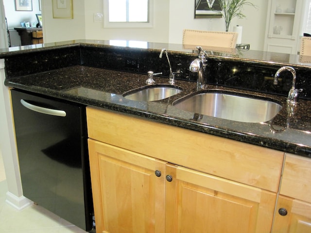 kitchen with sink, light tile patterned floors, dark stone counters, and dishwasher