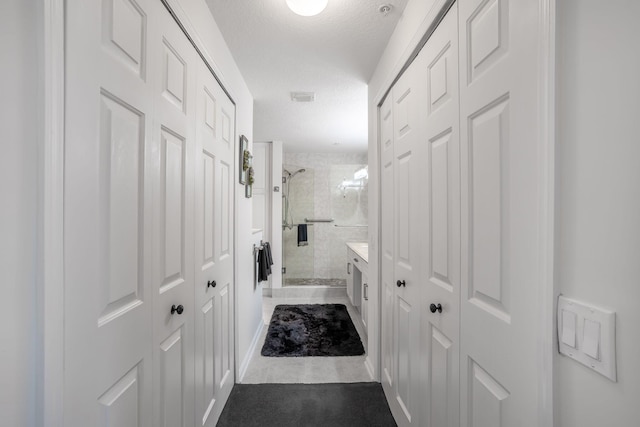 bathroom with an enclosed shower and a textured ceiling