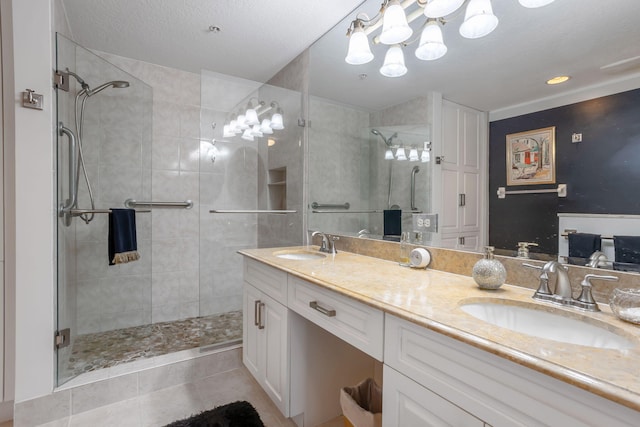 bathroom with tile patterned flooring, vanity, a textured ceiling, and walk in shower