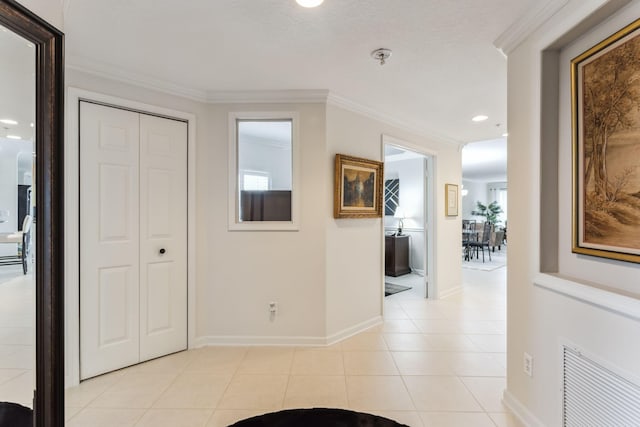 corridor featuring crown molding and light tile patterned floors