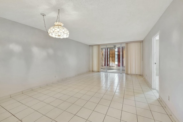 tiled empty room with a textured ceiling