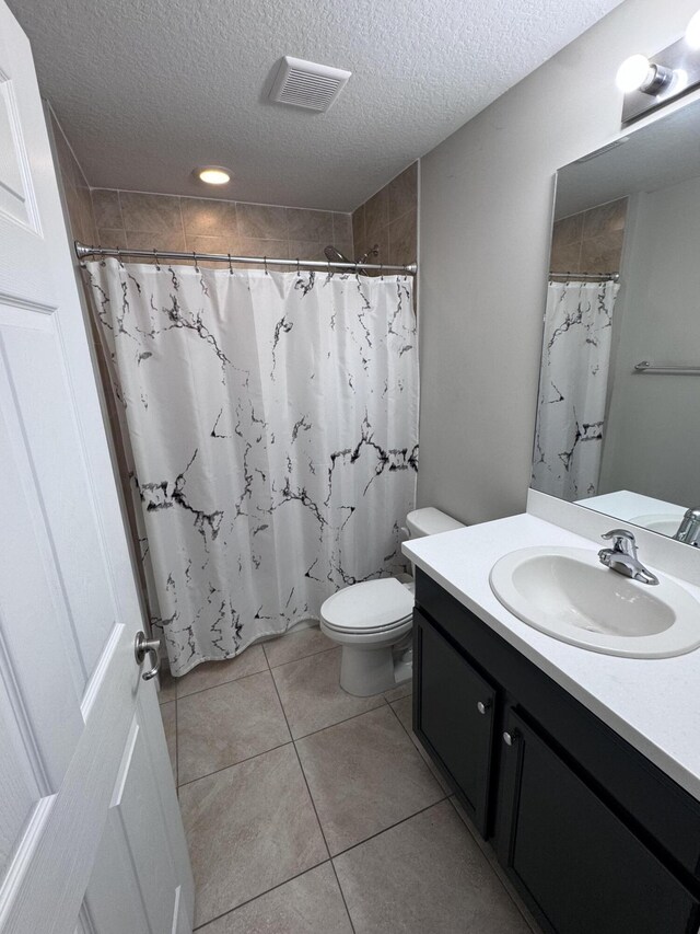 bathroom featuring a textured ceiling, tile patterned floors, vanity, and a shower with curtain