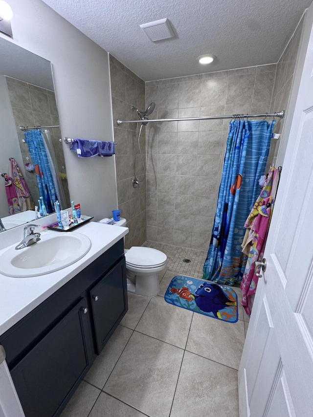 bathroom with a textured ceiling, tile patterned floors, vanity, and a shower with shower curtain