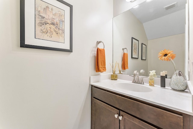 bathroom featuring vaulted ceiling and vanity