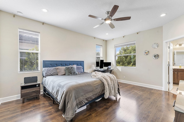 bedroom with ceiling fan, ensuite bath, dark hardwood / wood-style floors, and a textured ceiling