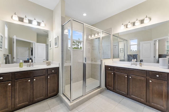 bathroom with walk in shower, vanity, and tile patterned flooring