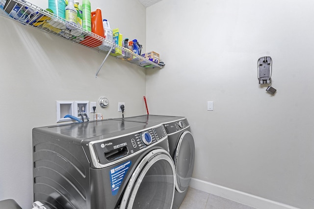 laundry room with washing machine and dryer and light tile patterned flooring