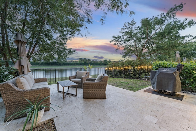 patio terrace at dusk featuring a water view and outdoor lounge area