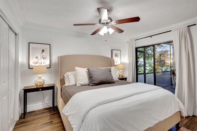 bedroom with ceiling fan, dark hardwood / wood-style floors, a closet, access to exterior, and crown molding