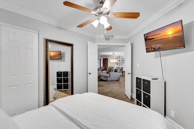 bedroom with ceiling fan, crown molding, and hardwood / wood-style floors