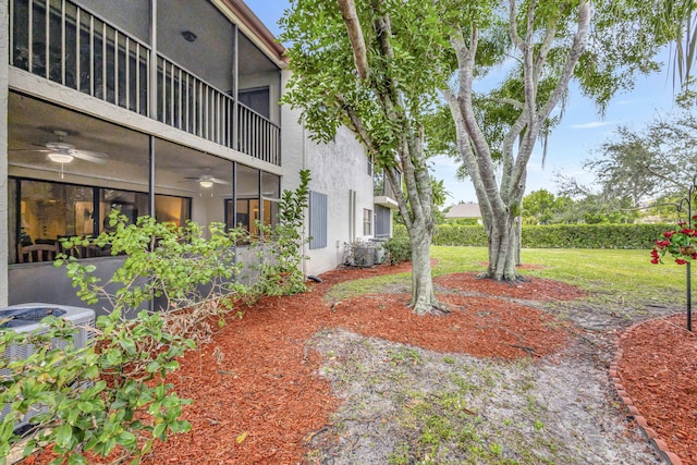 view of yard featuring ceiling fan and central AC