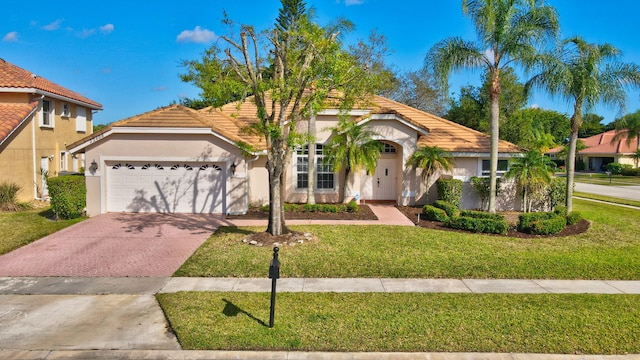 view of front of property with a garage and a front lawn