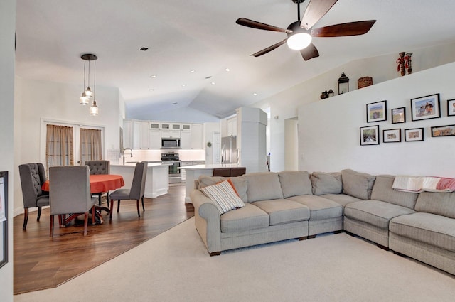 living room featuring sink, dark wood-type flooring, high vaulted ceiling, and ceiling fan