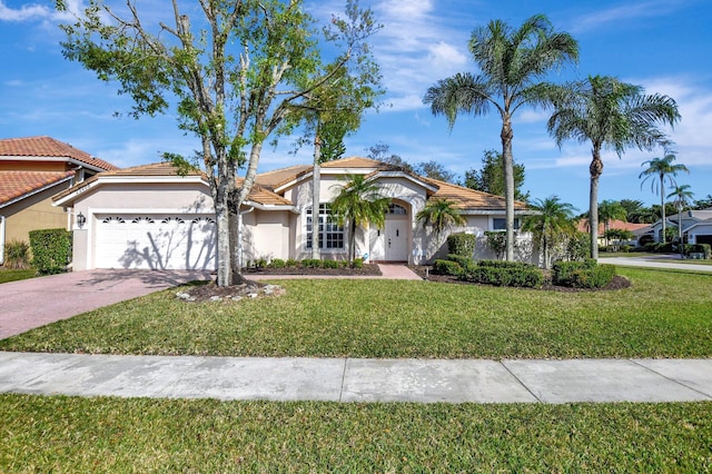 mediterranean / spanish house with a garage and a front yard