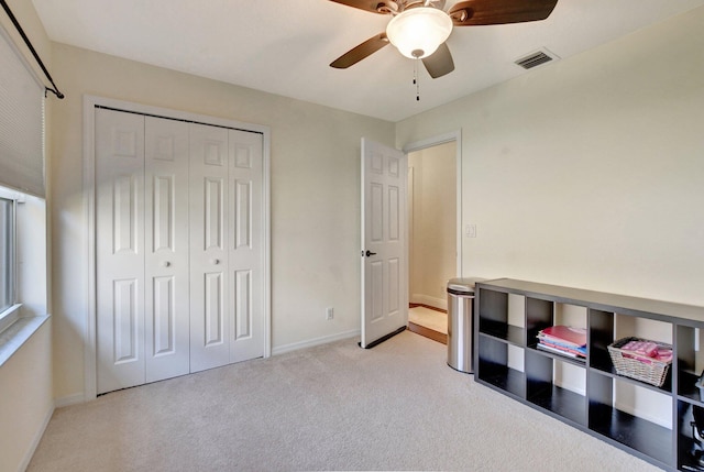 carpeted bedroom featuring a closet and ceiling fan