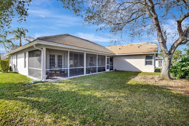 back of house with a sunroom and a lawn