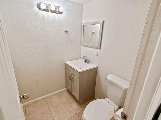 bathroom with vanity, tile patterned floors, and toilet