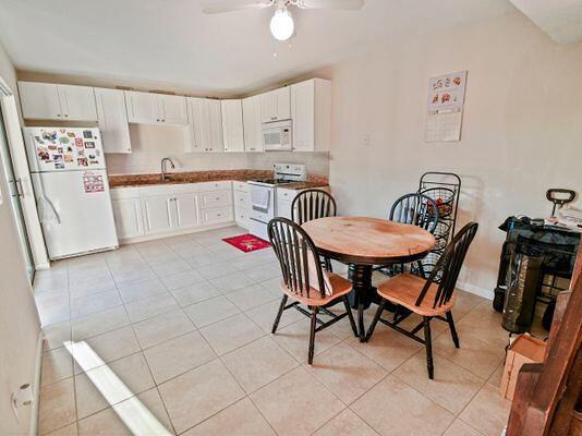 dining room featuring sink, ceiling fan, and light tile patterned flooring